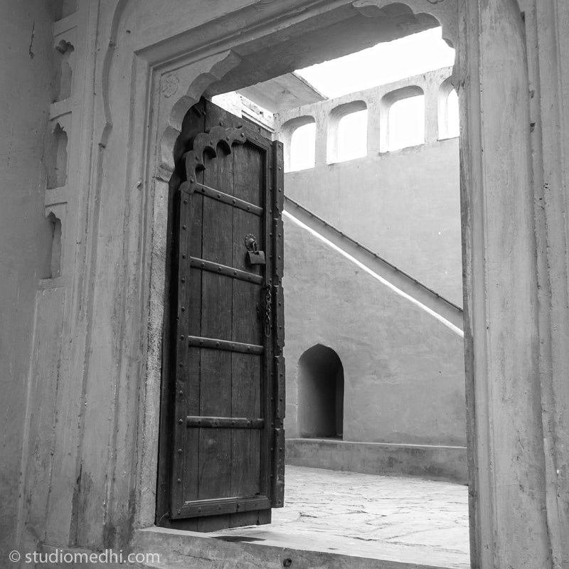 Experience the mesmerizing allure of the intricately carved wooden door entrance at Amer Fort, nestled in the heart of Amer, Rajasthan. Captured in exquisite detail by the renowned fine art photographer Hemant Medhi, this composition exudes the rich heritage and artistic charm of the region. Known for his masterful portrayal of heritage sites and abstract concepts, Medhi's lens beautifully encapsulates the timeless beauty of this architectural marvel.